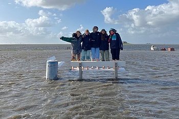 Freiwillige barfuß auf im Wasser stehender Bank