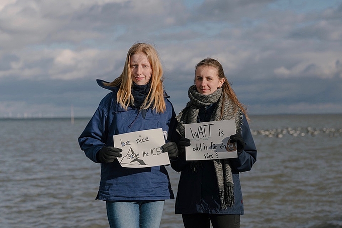 Freiwilligen-Team von Hallig Langeneß mit Plakaten.