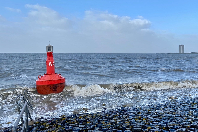 Rote Fahrwassertonne am Deich vor Büsum