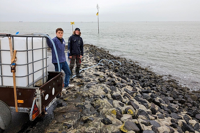 Zwei Freiwillige am Wasserwagen