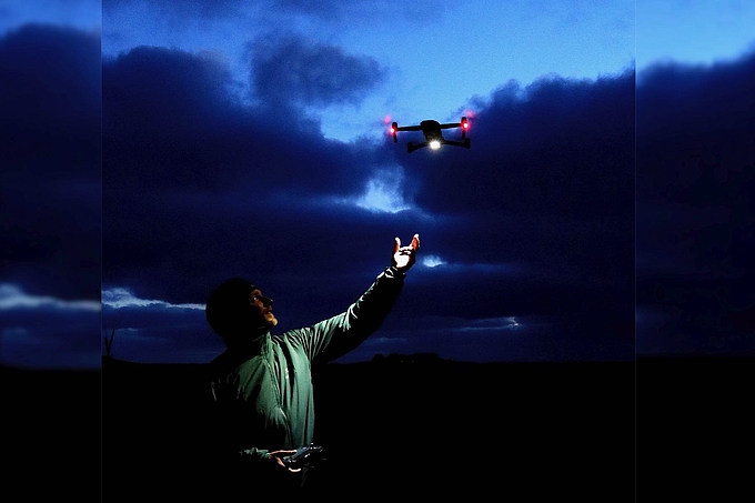 Benjamin Gnep mit über ihm fliegender Drohne