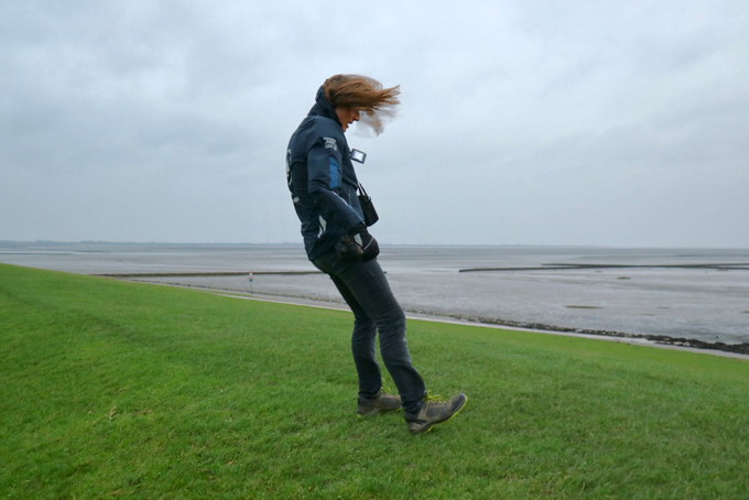 Freiwilliger steht mit fliegenden Haaren schräg im Wind