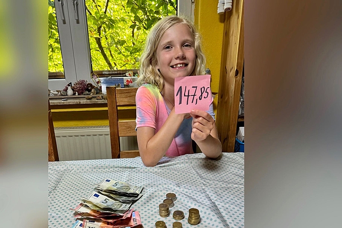 Emma mit Münzen und Scheinen vor ihr