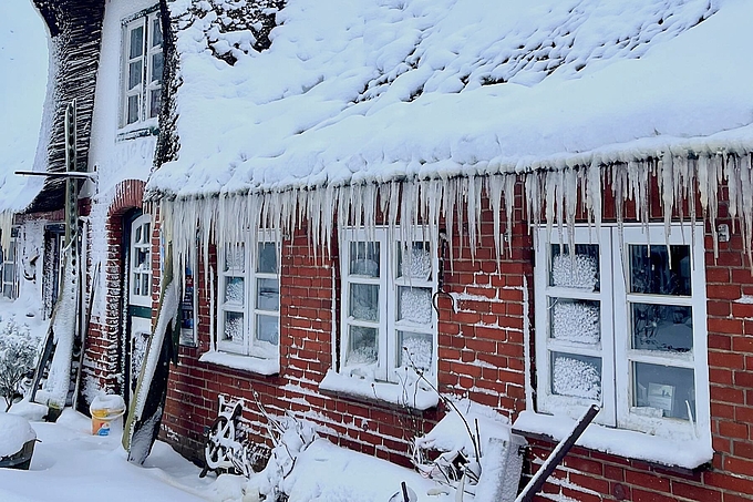 Reetdach mit langen Eiszapfen
