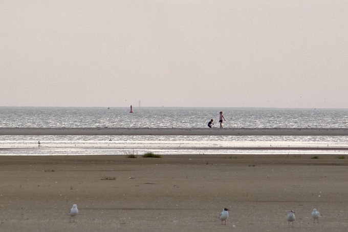 Kinder spielen vor Helgoland im Hintergrund