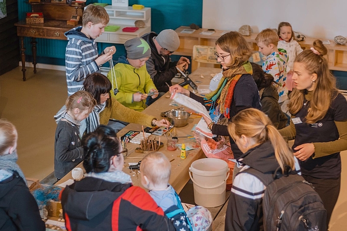 Freiwillige, Kinder und Erwachsene am Basteltisch