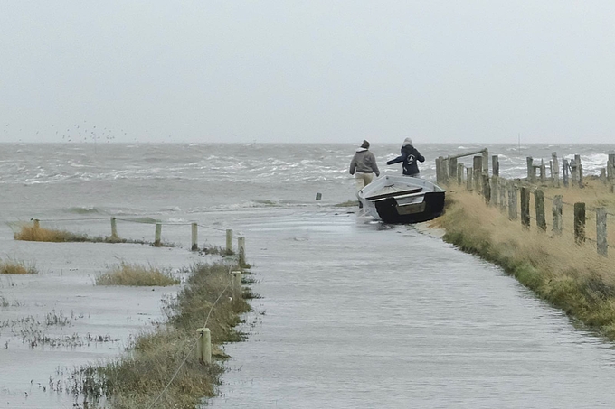 Zwei Freiwillige bei hohem Wasserstand am Rand der Hallig