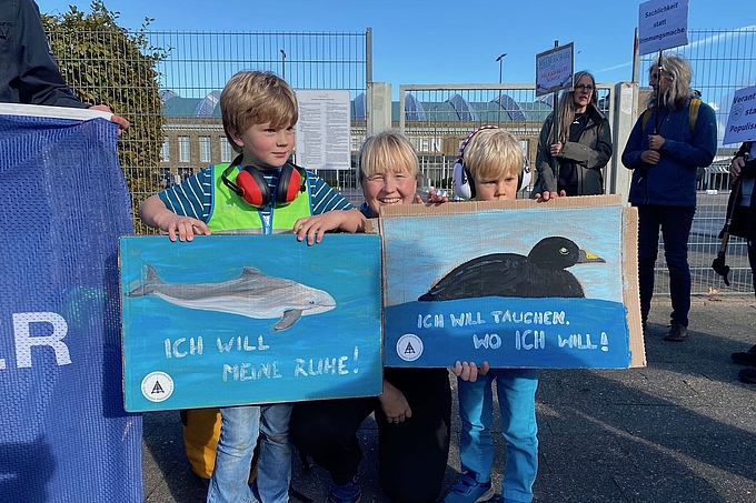 Familie mit zwei Kindern und Postern zu Schweinswalen und Meeresenten