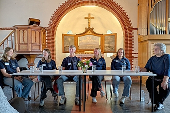 Gruppe sitzt vor Altar