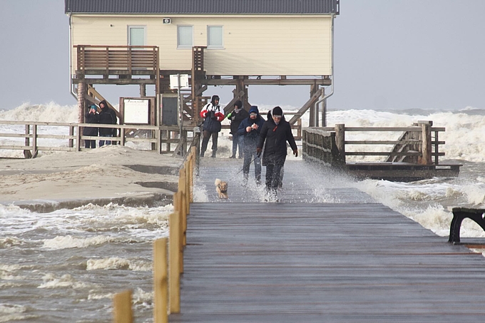 Wellen schlagen durch einen Steg vor St. Peter-Ording