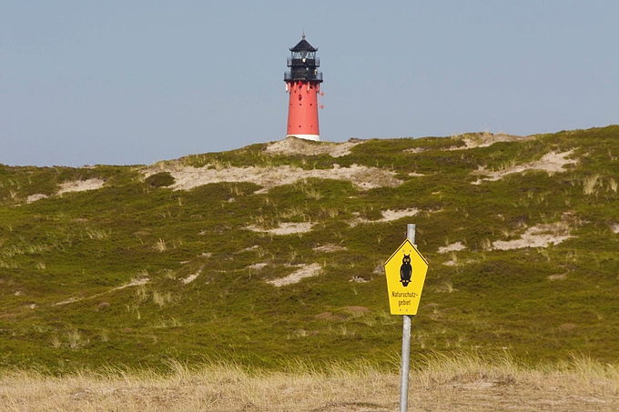 Dünen an der Odde mit Leuchtturm und Naturschutzgebietschild