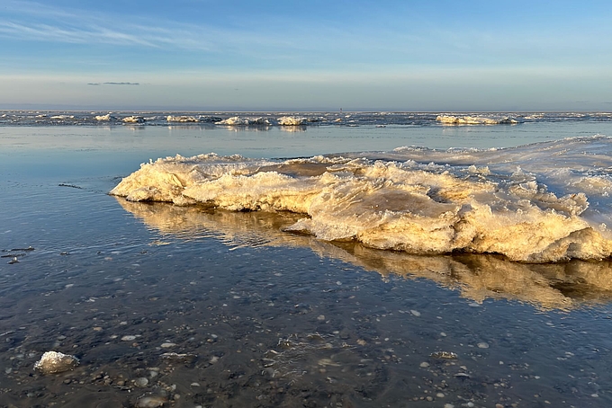 Eisschollen ragen aus flachem Wasser