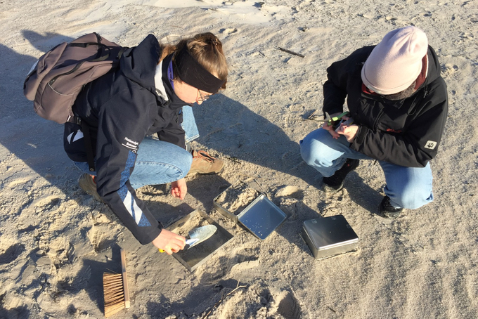 Freiwillige füllen Sand in Blechkiste