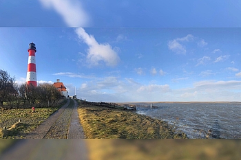 Panorama-Aufnahme des Leuchtturms mit noch überspülten Salzwiesen