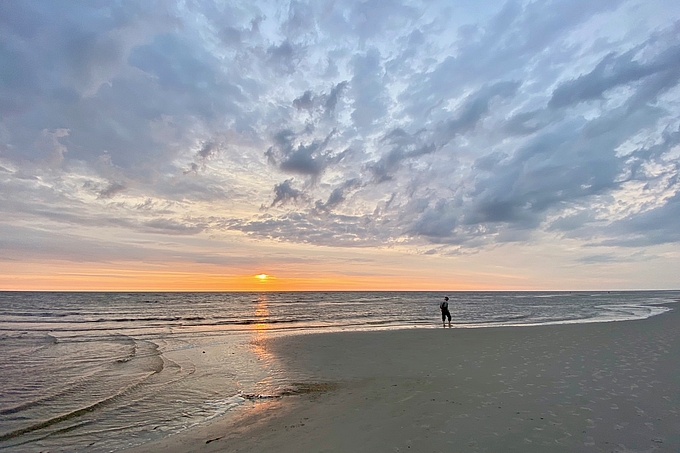 Schmaler Sonnenstreifen unter grauen Wolken