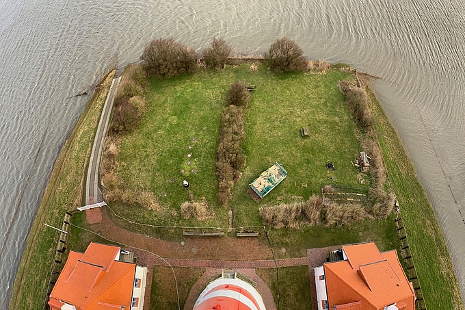 Blick vom Leuchtturm auf die umspülte Warft