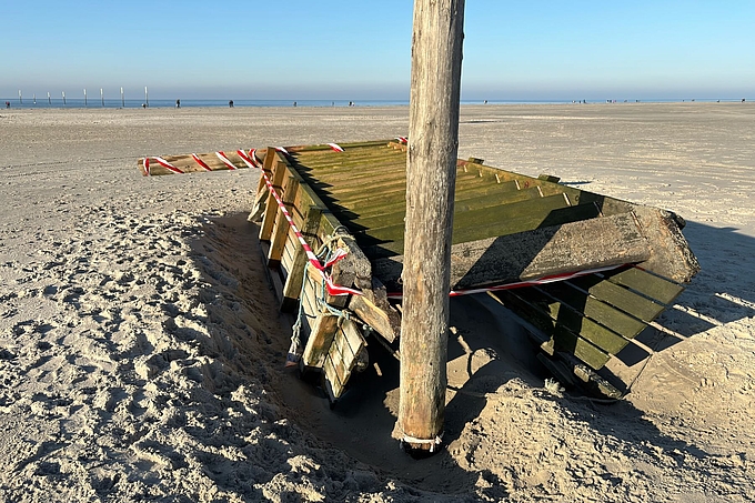 Beschädigte Treppe liegt auf dem Strand