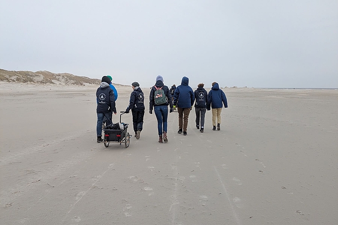 Gruppe mit Handwagen unterwegs vor den Dünen Gruppe mit Handwagen unterwegs vor den Dünen