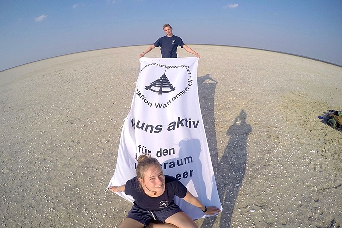 Freiwillige mit Flagge bei Vogelzählung auf Blauortsand