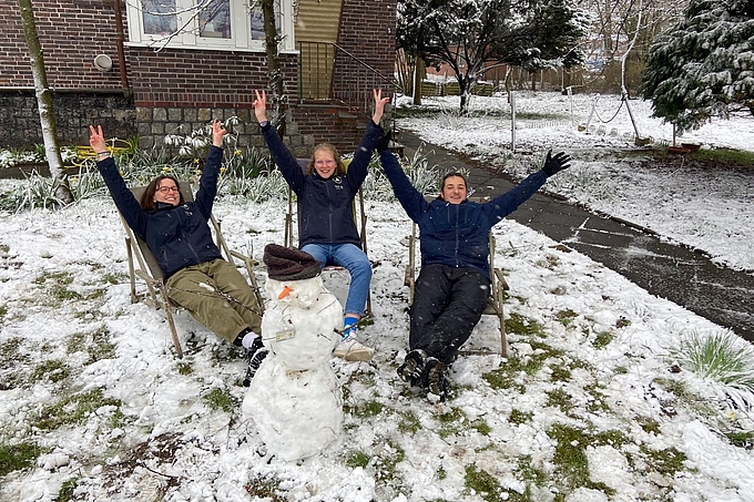 Drei Freiwillige mit Schneemann