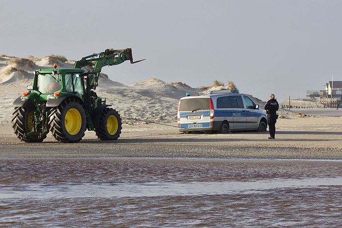 Trecker zieht Polizeiwagen aus lockerem Sand