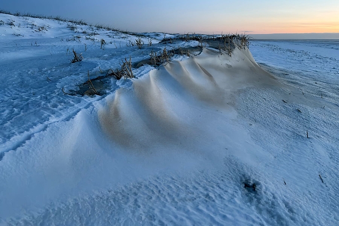 Schnee- und Sandfahnen an einer Düne