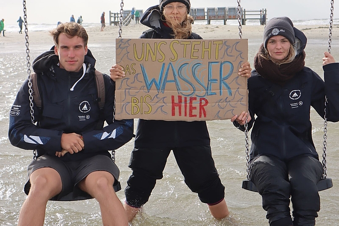 Uns steht das Wasser bis hier - Freiwillige mit Plakat