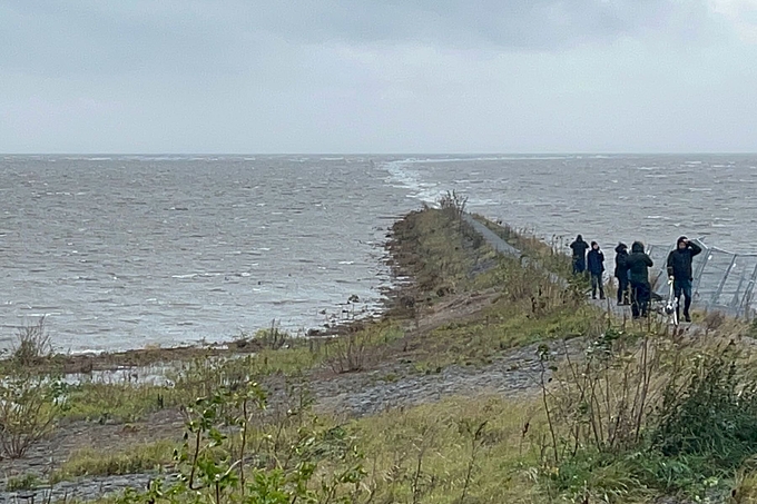 Personen am Beginn des Damms