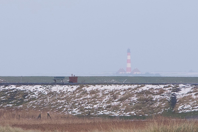 Blick über Schneereste zum Leuchtturm Westerhever
