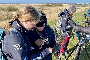 Freiwillige draußen mit Tablet-Computer