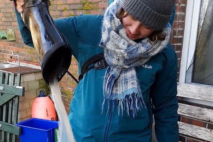 Freiwillige kippt Wasser aus dem Stiefel