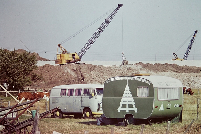 Wohnwagen mit Vereinslogo vor Deichbaustelle
