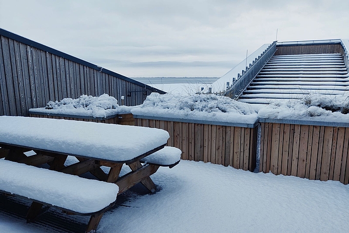 Blick über die verschneite Terrasse in den Koog