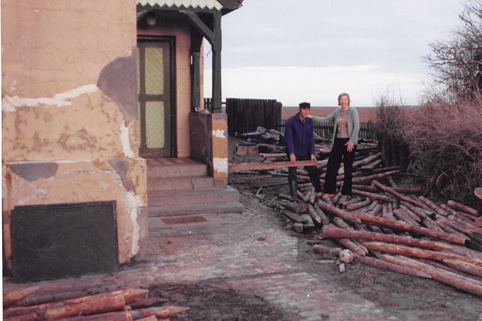 Zwei Personen stehen mit Holzlatte oberhalb der Knie