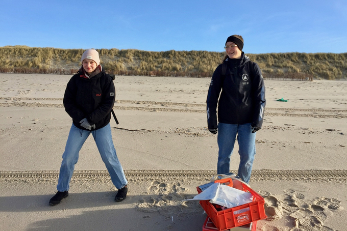 Zwei Freiwillige mit Gerätekiste am Strand