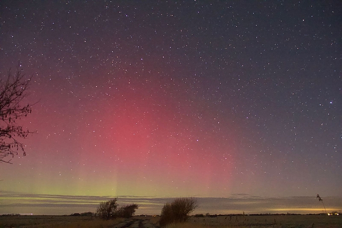 Kräftig rotes Polarlicht über grüner Basis