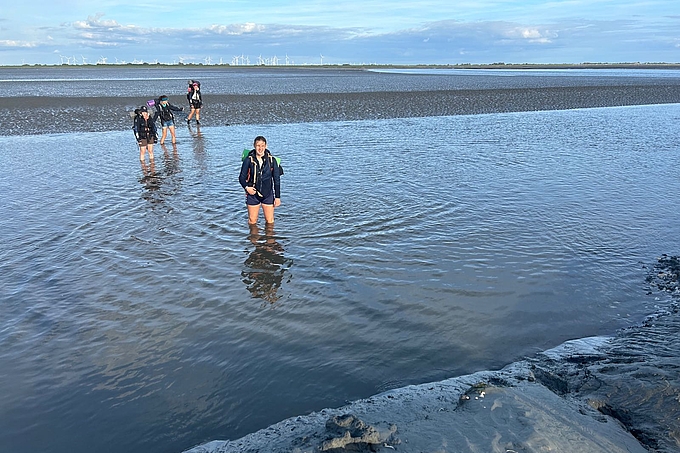 Gruppe in knietiefem Wasser im Priel