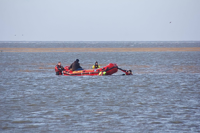 Rettungskräfte schieben Schlauchboot durch tiefes Wasser